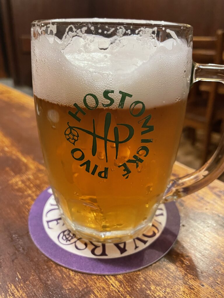 Draft Hostomická nalévárna pale lager in glass mug with brewery logo