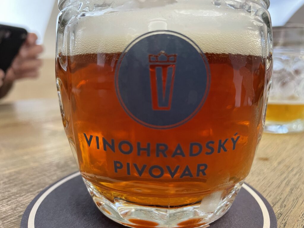 Draft Vinohradský amber lager in glass mug with brewery logo