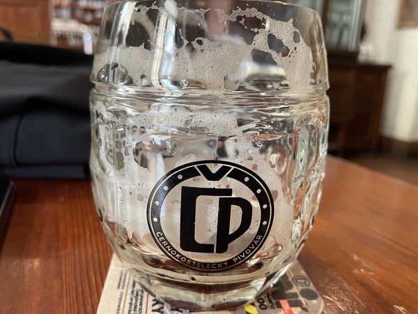 Dregs & lace from Černá Svině 13° lager in a glass with brewery logo