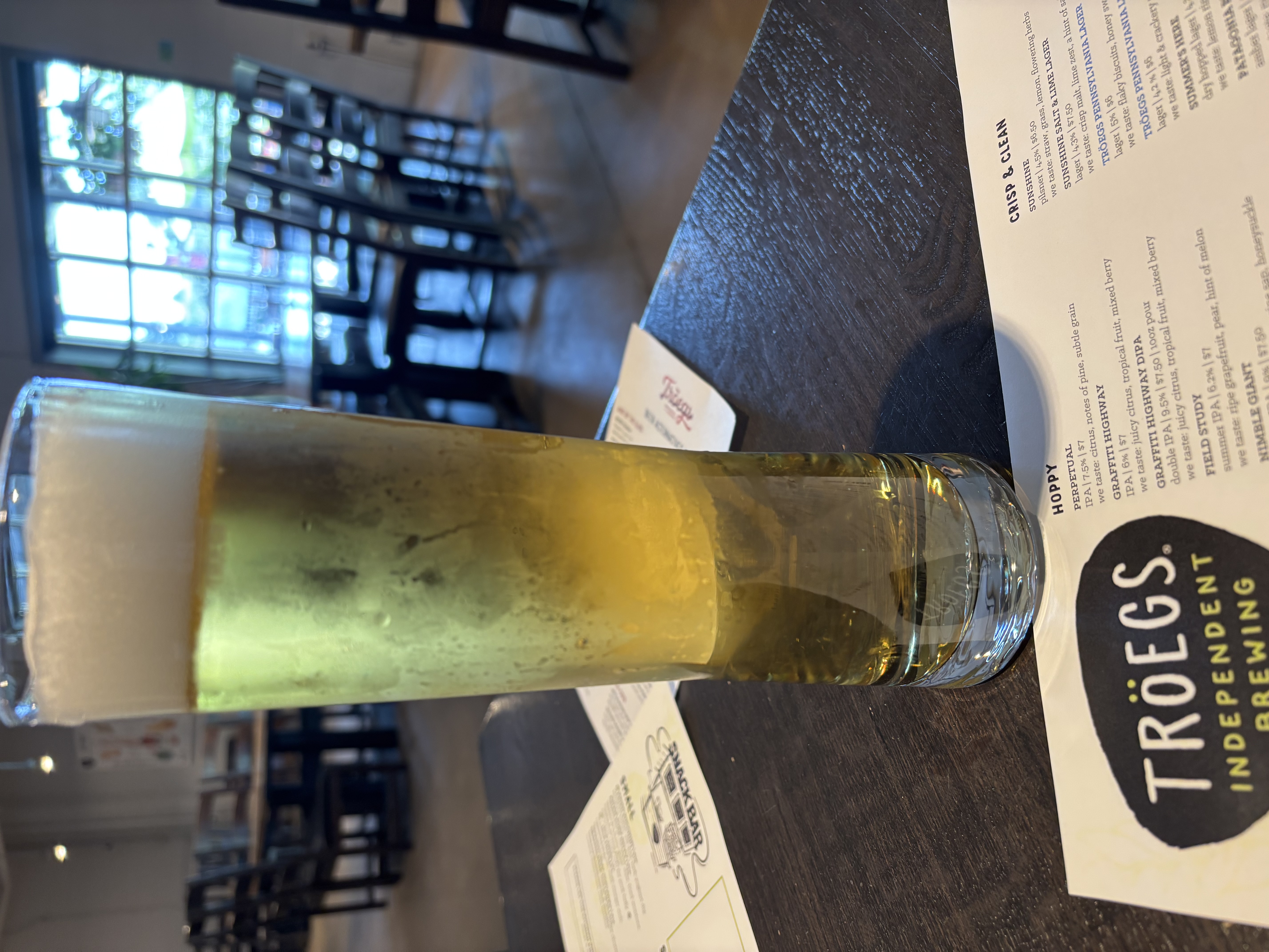 Light American Lager in a tall glass on a table at Tröeg’s