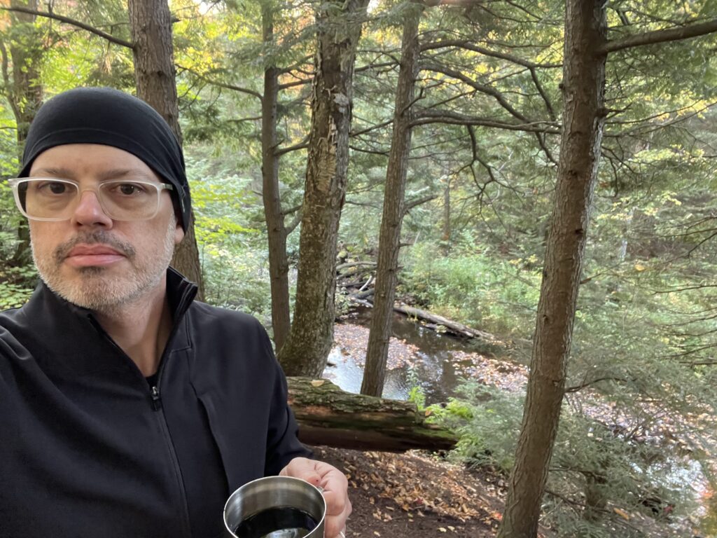 Me enjoying a cocktail at our campsite with the Little Carp River in the background